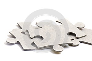 Close-up on jigsaw puzzle pieces, blank white paper jigsaw puzzle elements linked together and separate,