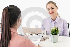 Close up of job interview focusing on woman handing resume with the office