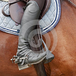 Close up of jockey riding boot, saddle and stirrup