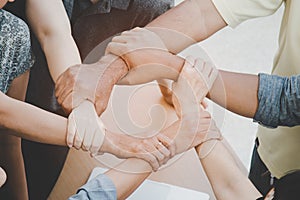 Close up of joining hands of businessman in unity cross processing background