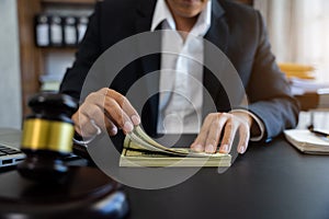 Close up of judge gavel and dollars on table. Law, auctioning, corruption, bankruptcy, bail, bribery or fines