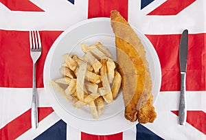 Close-up of junk food with fork and table knife over British flag