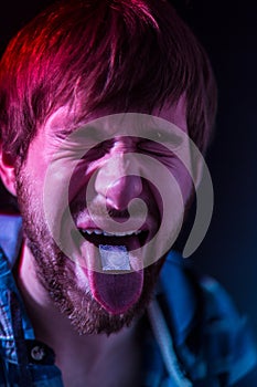 Close-up on junkie man taking LSD photo
