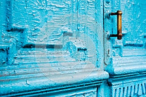 Close-up keyholes with curtains and a handle on the blue many times painted cracked double-barreled wooden vintage door