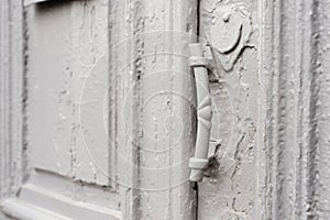 Close-up keyholes with curtains and a handle on the gray many times painted cracked double-barreled wooden vintage door