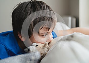 Close up kid eyes,Emotional portrait of caucasian kid sitting next to window with thinking face,Upset little boy sitting alone,