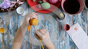 Close up of kid hands coloring easter eggs with egg dye. View from above