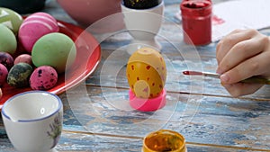 Close up of kid hands coloring easter eggs with egg dye. View from above