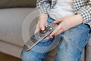 Close-up kid hands holding TV remote controller. Boy without parental control watching television