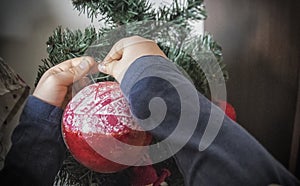 A close-up of kids hands with a Christmas ornament