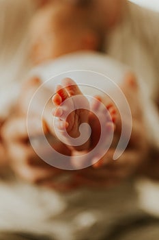 Close up of kids legs in mom`s hands. Tenderness. Family concept