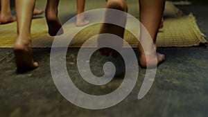 Close up for kids legs running barefoot on yellow mat, rear view. Scene. Children legs running indoors without shoes on