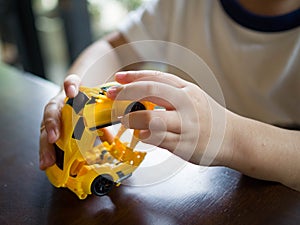 Close up of kids`s hand playing with a plastic toy car