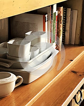 Close-up of kitchen country hutch with white dishes and cookbooks.  Image taken on slight angle. photo