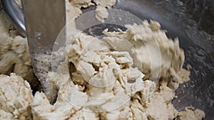 Close up for kneating dough in the industrial bakery dough mixer. Stock footage. Automatic equipment for pastry mixing