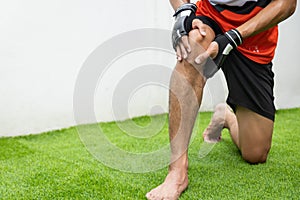 Close up on knee Injury. The man use hands hold on his knee while running in the park. space for text or design