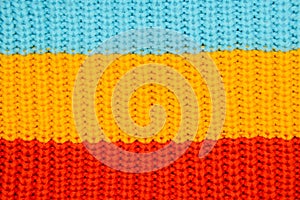Close-up of knitted cotton texture - three wide horizontal stripes of blue, yellow and red