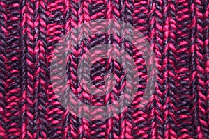 Close-up knitted texture in magenta color palette. Winter texture concept, knitted clothing