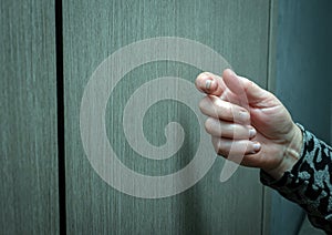 Close-up Knocking on the door of an elderly woman, a woman\'s hand knocks on a wooden door, a visit