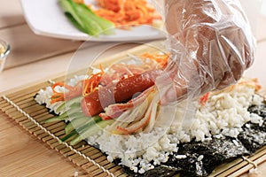 Close Up Korean Female Making Gimbap, Korean Roll Rice with Sausace, Kyuri, Carrot, and Crabstick