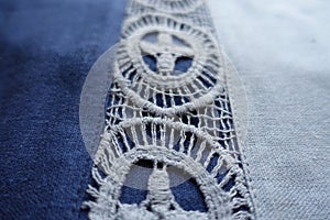 Closeup of lace on blue linen fabric