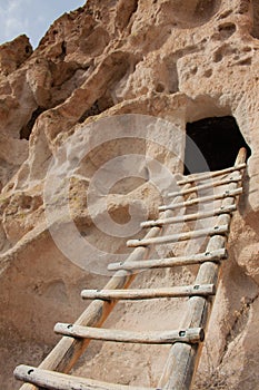 Close-up of ladder leading up to ancient cliff dwelling entrance at Bandelier National Monument in New Mexico desert