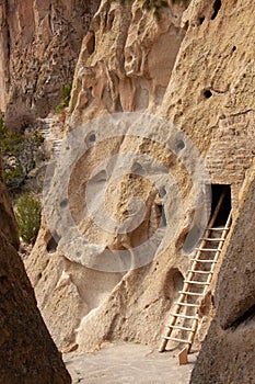 Close-up of ladder leading up to ancient cliff dwelling entrance at Bandelier National Monument in New Mexico desert
