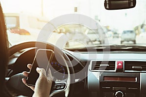 Close up of a lady driving car dangerously while using mobile phone photo