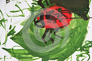 Close up. Ladybug beetle on green leaf. Children`s drawing paints. Creative activities with children 4-5 years old on the