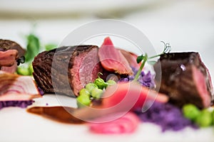 Close up of lamb chops with pea and purple potatoes