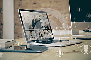 Close up of laptop on desk with glowing video conference hologram and polygonal connections on blurry office background. Remote