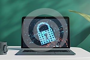 Close up of laptop with safety padlock icon on screen and on blurry blackboard background. Desktop with coffee cup. Secure,