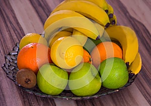 Close up of a large bowl full with lemons, bananas and other fruits