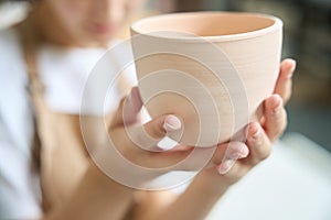 Close-up of a large clay cup in female hands