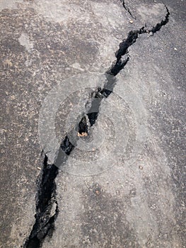 Close-up of large crack in asphalt, concept of neglect and damage