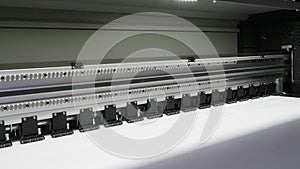 A close up of a large format inkjet printer in operation