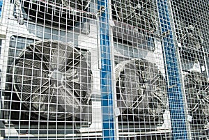 Close up of large industrial air conditioning fans behind a  protective gratings