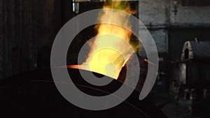 Close-up of large iron melting furnace with yellow-green flame in the top on the old metallurgic factory or plant. Stock