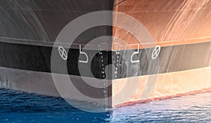 Close up of large merchant cargo ship in the middle of the ocean underway. Performing cargo export and import operations