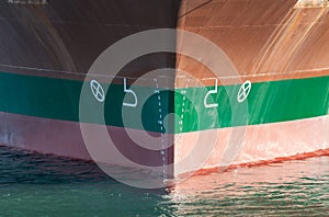 Close up of large merchant cargo ship in the middle of the ocean underway. Performing cargo export and import operations