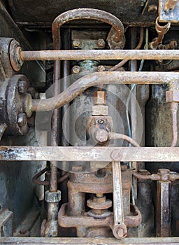 Close up of a large old abandoned marine diesel engine showing rusting pipes and cylinders and bolts