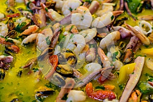 Close up of large portion of mixed seafood cooked with vegetables, available for sale at a street food market, top view or flat la
