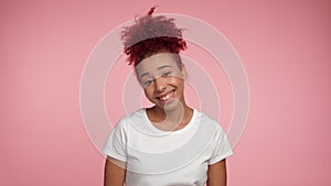 Close up laughing happy young African American redhead curly woman looks camera