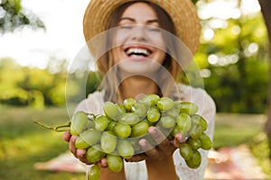 Close up of laughing young girl in summer hat spending time at the park