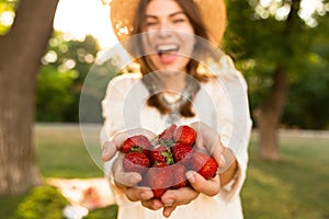 Close up of laughing young girl in summer hat spending time at the park