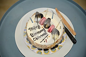 A close up of a lavish design birthday cake placed on a blue bottom