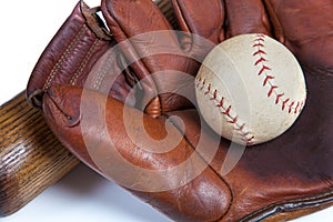 A close up of a Leather baseball glove, ball an wooden bat