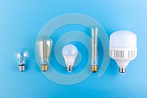 close up led lamps and edison lamps lie flat on an isolated blue background. Energy efficiency concept.