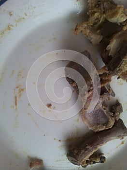 Leftover chicken bones in a white ceramic plate