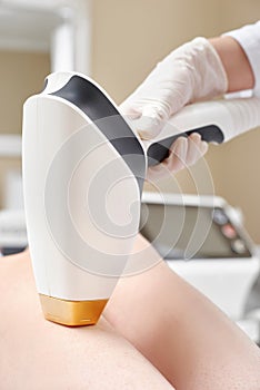 Close up - leg hair removal session with laser device at beauty parlor.